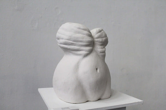 Uncomfortable ceramic sculpture featuring a curvy, abstract design in white, showcasing unique textures and forms.